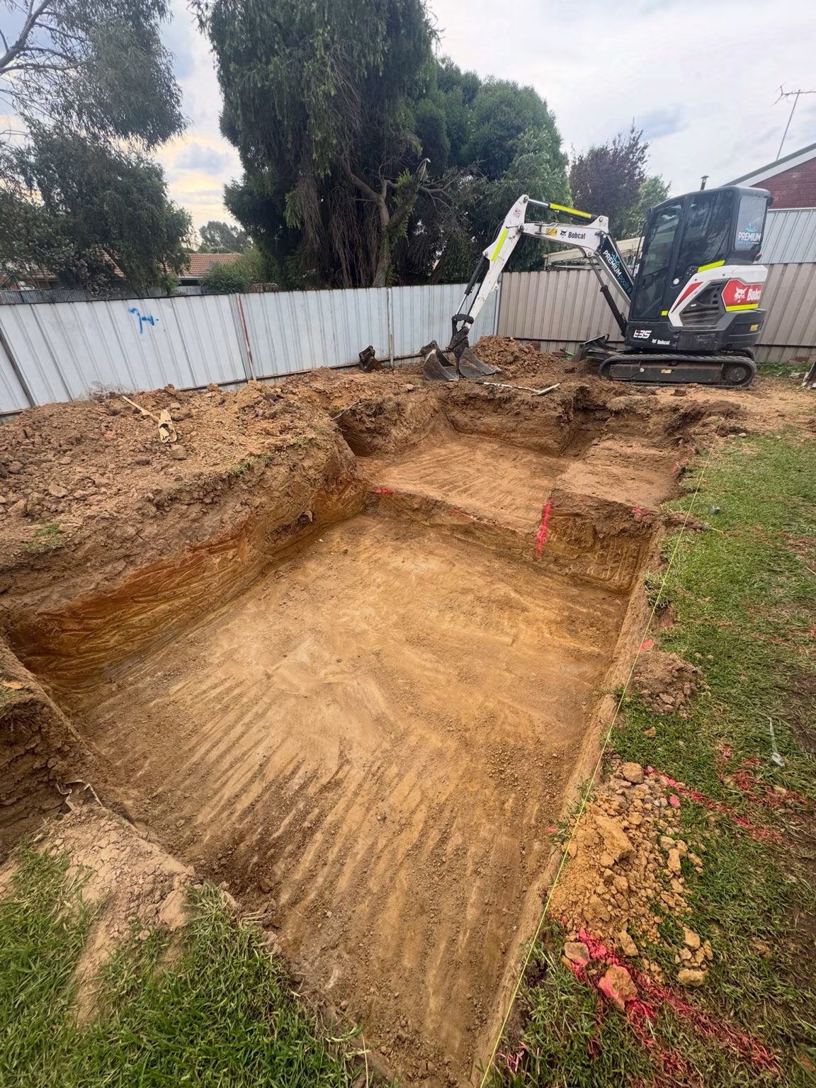 Mini excavator completing a pool excavation