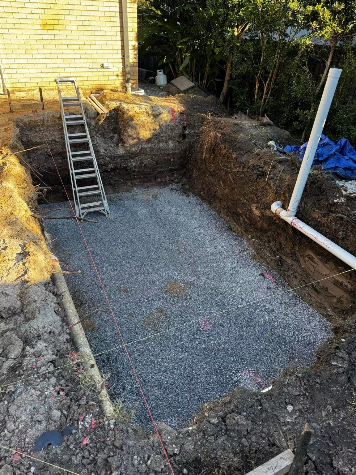 Excavated site base with installed drainage